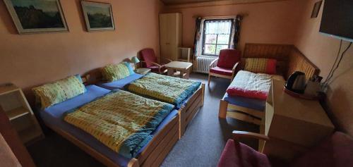 Zimmer mit 2 Betten, einem Sofa und einem Schreibtisch in der Unterkunft Penzion U Dvou pánů in Pernink