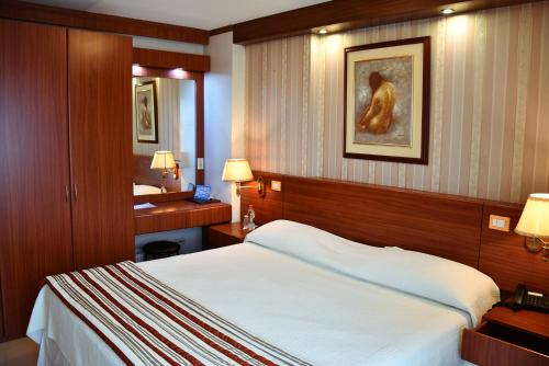 a hotel room with a bed and a mirror at REGAL HOTEL in Machala
