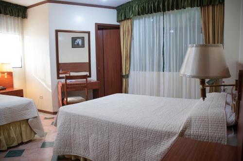 a hotel room with a bed and a table and a mirror at REGAL HOTEL in Machala