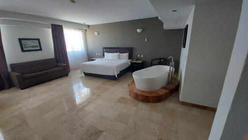 a hotel room with a bed and a bath tub at Imperio de Angeles Executive León Poliforum in León