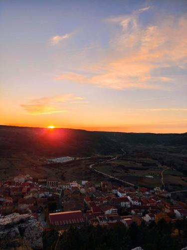 a sunset view of a city with the sun setting at Alojamientos Rurales La Hoz in Beteta