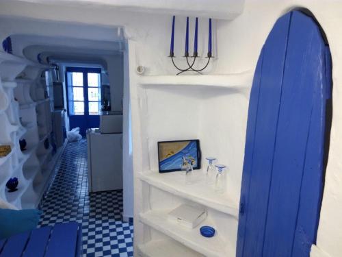 Una tabla de surf azul colocada en un estante en una habitación. en Casa El Grial, en Peñíscola