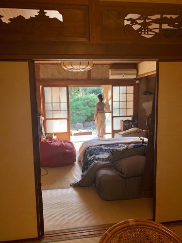 a man standing in a room with two beds at Ensoh in Okayama