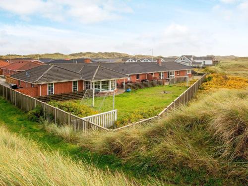 a row of houses on the beach with grass at 16 person holiday home in Hvide Sande in Hvide Sande