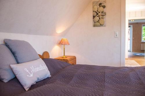 um quarto com uma cama e um candeeiro sobre uma mesa em Haus-Wiwibarg-OG em Dahme