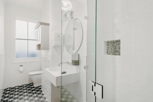 a white bathroom with a sink and a shower at The Victoria Hotel Bathurst in Bathurst