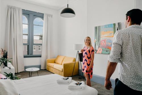 a man and a woman standing in a hotel room at The Victoria Hotel Bathurst in Bathurst