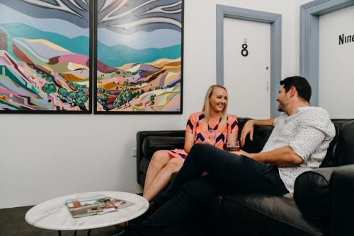 a man and a woman sitting on a couch at The Victoria Hotel Bathurst in Bathurst