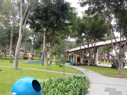 een blauw object in een park met een gebouw bij Sucesac in Lima