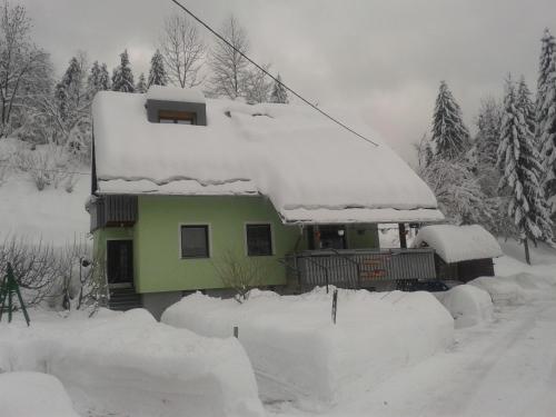 a house covered in snow on a ski lift at Apartment Žvan in Bohinj