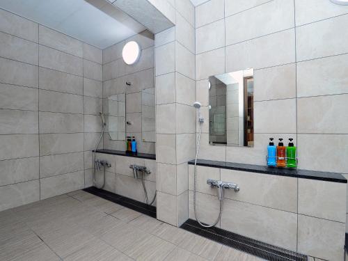 a bathroom with a shower and a mirror at Ryokan Seifuso in Matsumoto