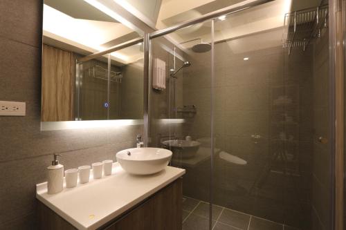 a bathroom with a sink and a glass shower at MU House in Taipei