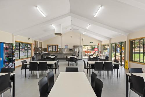 a dining room with tables and chairs and windows at Discovery Parks - Barossa Valley in Tanunda