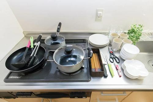a stove top with pots and pans on top of it at EX2 Higashimikuni Hous in Osaka