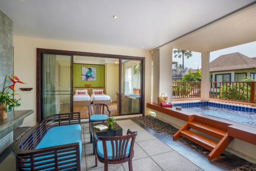 a living room with a swimming pool and a bedroom at The Briza Beach Resort, Samui - SHA Plus in Chaweng