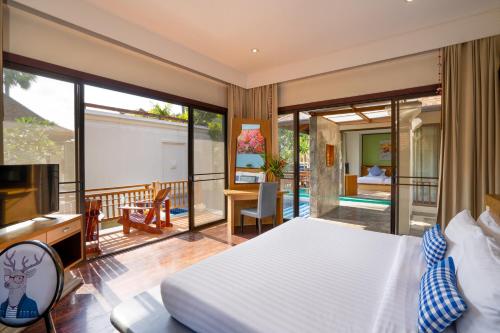 a bedroom with a bed and a balcony at The Briza Beach Resort, Samui - SHA Plus in Chaweng
