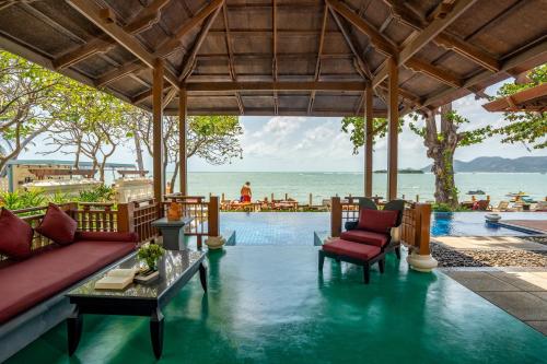 a resort with a pool with chairs and a table at The Briza Beach Resort, Samui - SHA Plus in Chaweng