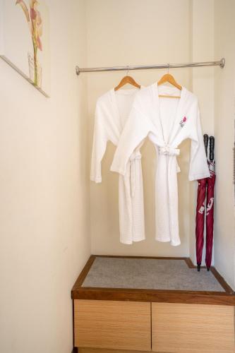 a wardrobe with white shirts and red shoes at The Briza Beach Resort, Samui - SHA Plus in Chaweng