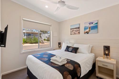 a bedroom with a large bed and a window at Discovery Parks - Lake Bonney in Barmera