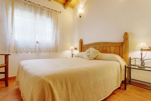 Casa Rural Juzcar في خوثكار: غرفة نوم بسرير كبير ونافذة
