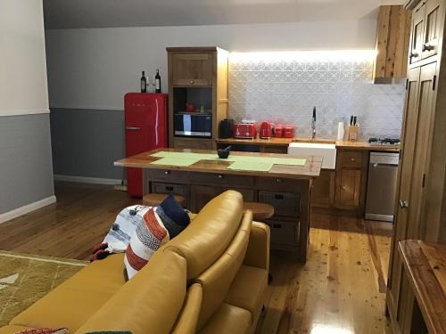 a kitchen with a couch and a red refrigerator at Mudgee Apartments on George Street in Mudgee
