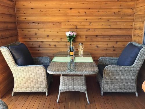 a table with two chairs and a vase with flowers at Mudgee Apartments on George Street in Mudgee