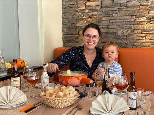 a woman and a child sitting at a table at Boutique und Bier Hotel des alpes in Fiesch