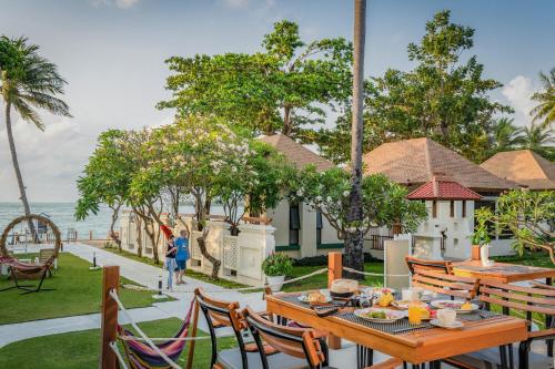 a patio with tables and chairs and the ocean at The Briza Beach Resort, Samui - SHA Plus in Chaweng