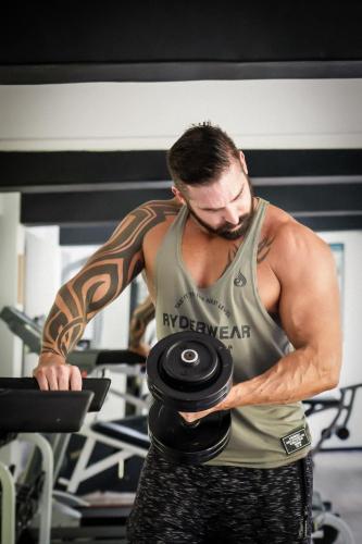 a man in a gym holding a bunch of dumbbells at The Briza Beach Resort, Samui - SHA Plus in Chaweng