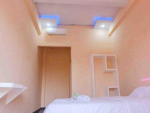 Artayya Puri 2 near Alun Alun Caruban Mitra RedDoorz في ماديون: غرفة بها سرير مع أضواء زرقاء على السقف