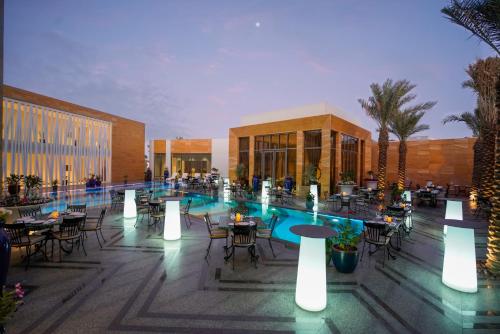 a resort with a pool and tables and chairs at Vivienda Hotel Villas, Jeddah in Jeddah