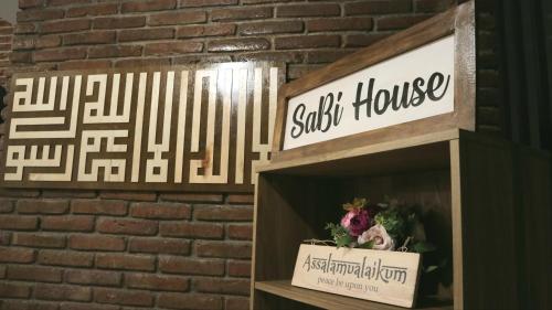 a sign for a salt house on a brick wall at SaBi Guest House - Strategic Family -married couples only- Hostel in Prawirotaman in Yogyakarta