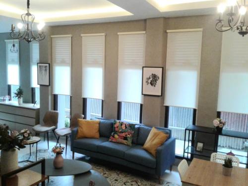 a living room with a blue couch and some windows at SaBi Guest House - Strategic Family -married couples only- Hostel in Prawirotaman in Yogyakarta