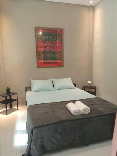 a bedroom with a large bed with two towels on it at SaBi Guest House - Strategic Family -married couples only- Hostel in Prawirotaman in Yogyakarta