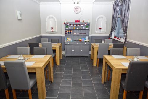 a dining room with wooden tables and chairs at Mallowview Bed and Breakfast in Cleethorpes