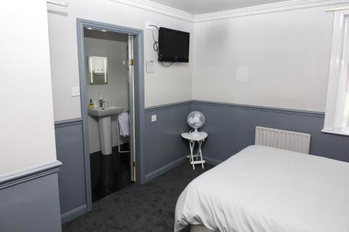 a small room with a bed and a sink at Mallowview guest house in Cleethorpes