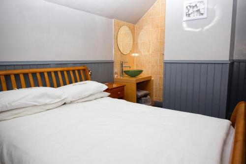 a bedroom with a white bed and a sink at Mallowview guest house in Cleethorpes