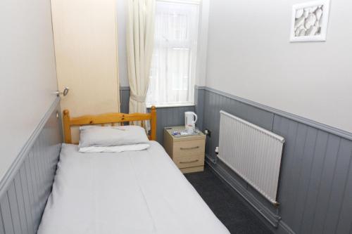 a small bedroom with a bed and a window at Mallowview guest house in Cleethorpes