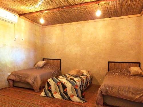 1 dormitorio con 2 camas en una habitación en Al Khateem Art Hub, en Baţīn