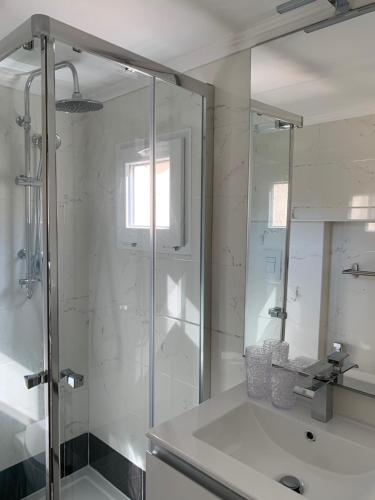 ein weißes Bad mit einer Dusche und einem Waschbecken in der Unterkunft Luxury Apartment in Rome Countryside - Francigena in Campagnano di Roma