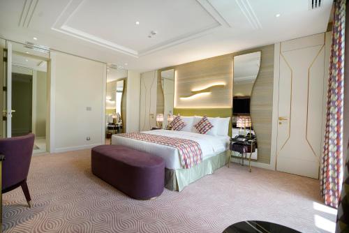 a hotel room with a bed and a purple chair at Vivienda Hotel Villas, Jeddah in Jeddah