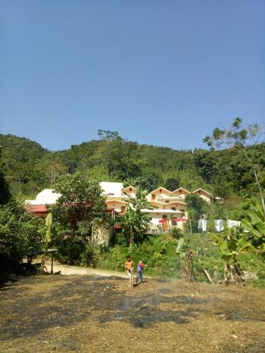 two children walking down a dirt road in front of a house at Hoa Lan Hotel in Bak Kan