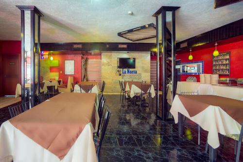 a restaurant with tables and chairs in a room at Hotel Torre in Monterrey