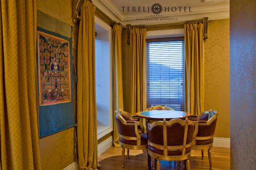 a table and chairs in a room with a window at Terelj Hotel & Spa in Ulaanbaatar