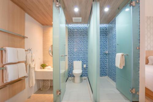 a bathroom with a toilet and a glass shower at The Briza Beach Resort, Samui - SHA Plus in Chaweng