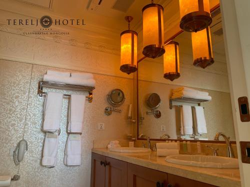 a bathroom with two sinks and a large mirror at Terelj Hotel & Spa in Ulaanbaatar