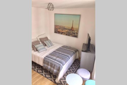 a bedroom with a bed and a picture of the eiffel tower at French typical apartment (opéra 5D) in Paris