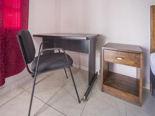 a black desk with a chair next to a wooden table at Hotel Posada Santa Elena in Parras de la Fuente