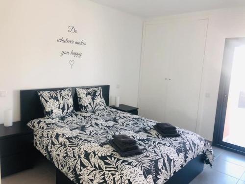 uma cama com lençóis e almofadas preto e branco em Bela Concha - Bela Baia 3 em Salir de Porto