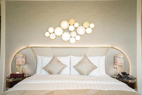 a bedroom with a white bed with two lamps at Vivienda Hotel Villas, Jeddah in Jeddah
